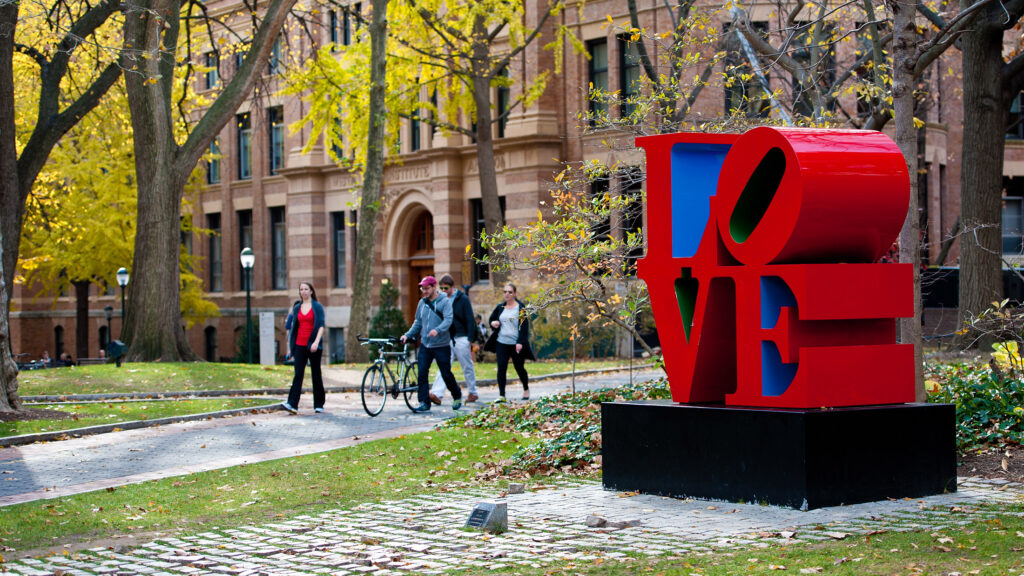 Students walking past the LOVE statue on Penn's campus